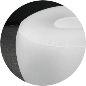 A close-up of white, inflatable furniture reveals a round chair with a smooth surface, set against a dark background. The focus is on the top and side of the chair.