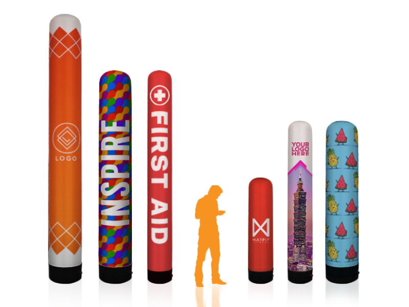 Six colorful inflatable air towers with diverse designs and text, including LOGO, INSPIRE, FIRST AID, and YOUR LOGO HERE, are arranged in a line. Each tower features vibrant patterns and emblems.