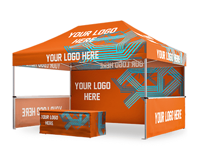 An orange and blue 10x15 pop up canopy tent with a table underneath, both displaying the text Your Logo Here and abstract geometric designs. The tent is open on three sides, revealing supporting poles and a flat roof.