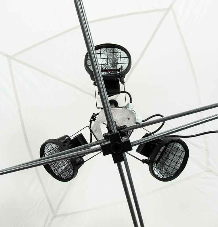 Close-up view of the Heating Kit for Pop-Up Canopy, featuring three elements mounted on intersecting metal rods. The kit is designed to direct warmth upwards, with a translucent white background ensuring even heat distribution.